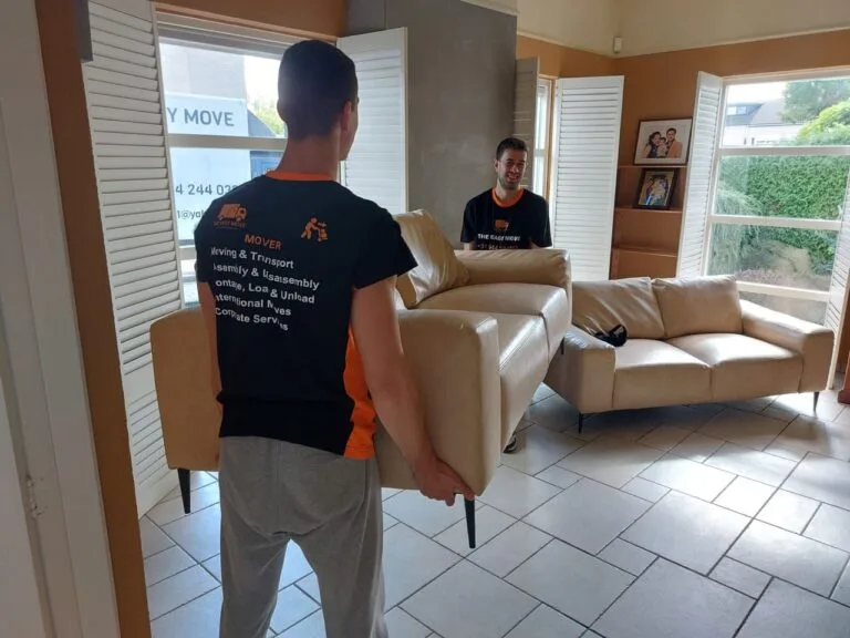 Friendly movers in Madrid carrying a sofa